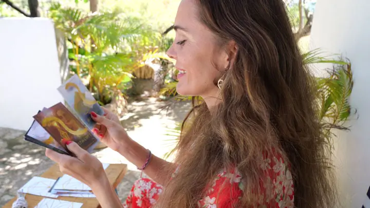 Jacqueline Le Saunier haelt ihr Orakel-der-Intuition-Kartenset - Seitenansicht